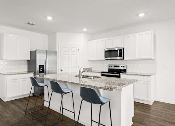 A kitchen with white cabinets and a granite countertop.