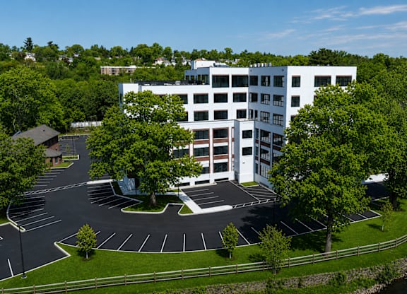 A white building with a parking lot in front of it.