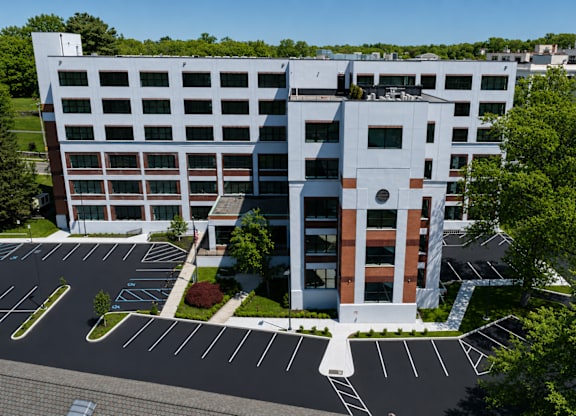 A modern building with a parking lot in front.