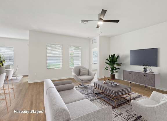 A living room with a grey couch, a chair, a coffee table, and a television.