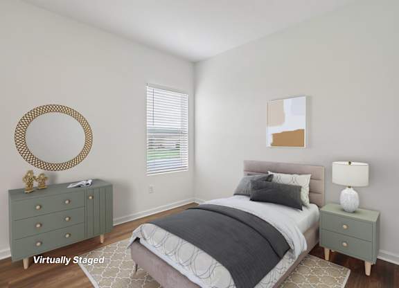 A bedroom with a bed, nightstand, and a mirror on the wall.