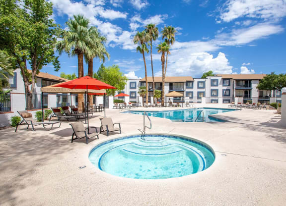 a resort style pool with palm trees and a building in the background