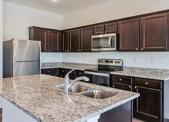 A kitchen with granite countertops and stainless steel appliances.