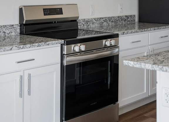 A black oven is in a white kitchen.