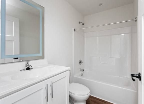A white bathroom with a toilet, sink, and bathtub.