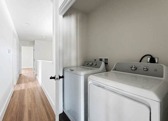 A white washing machine and dryer in a laundry room.