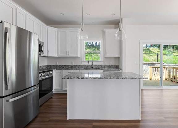 A kitchen with a marble countertop and stainless steel appliances.