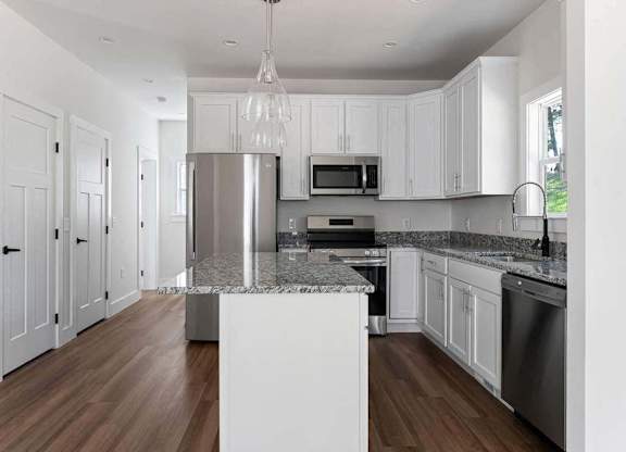 A modern kitchen with white cabinets and a central island.