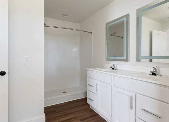A white bathroom with a walk in shower.