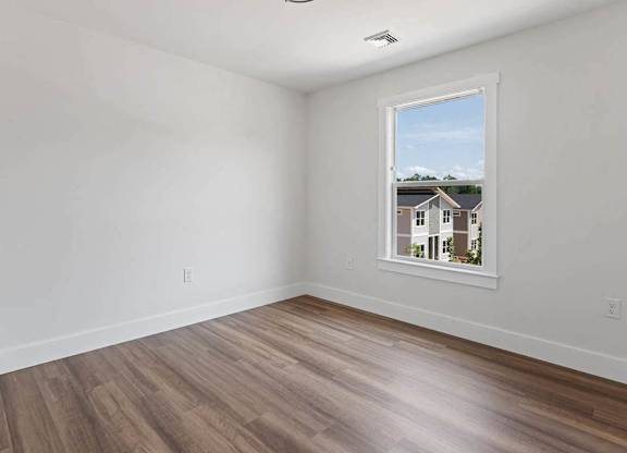 A room with a window showing a view of houses.