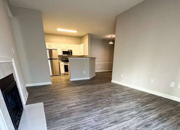 A living room with a grey floor and a television on the left side.