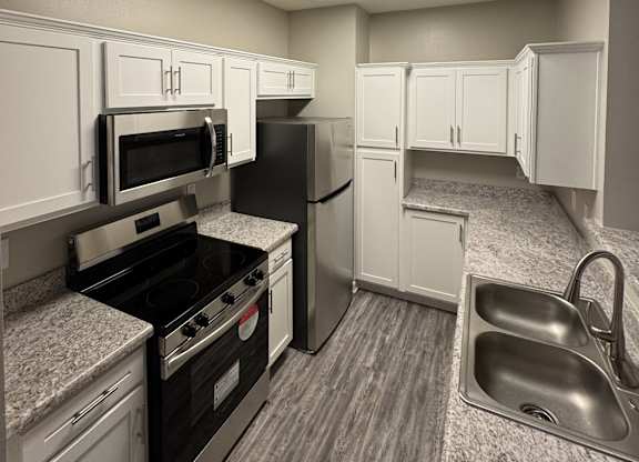 A kitchen with black appliances and white cabinets.