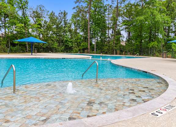 Homes for Rent with Attached Garage in Conroe, TX - Amber Pines at Foster's Ridge - Swimming Pool with Fountains, Umbrellas, Surrounded by Tall Trees