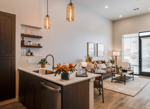 A kitchen with a sink, a counter, and a dishwasher.