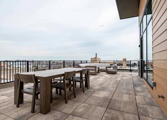 A wooden table and chairs are set up on a wooden deck.