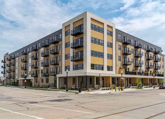 A large apartment building with balconies on the second floor.