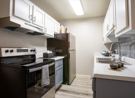 Dog-Friendly Apartments in Tucson, AZ - Peaks at Redington - Kitchen with Wood-Style Flooring, Two-Tone Cabinetry, Countertops, Double-Sink, and All-Electric Appliances.
