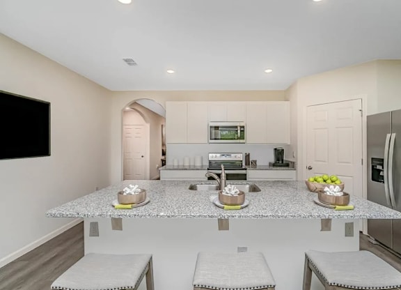 A kitchen with a granite countertop and stainless steel appliances.