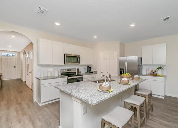 A kitchen with a counter and stools.