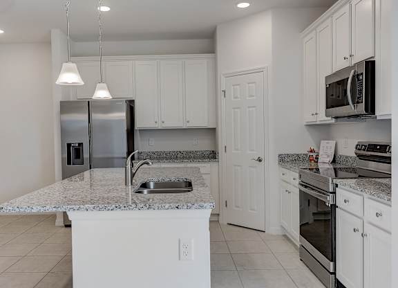 A kitchen with white cabinets and appliances.