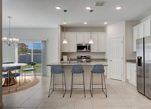 A modern kitchen with a bar area and a refrigerator on the right.