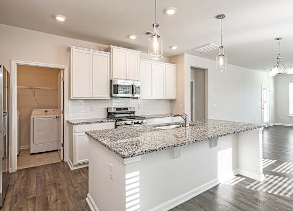A kitchen with a granite countertop and white cabinets.