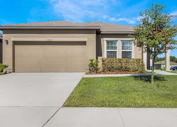 A house with a brown garage door and a driveway.