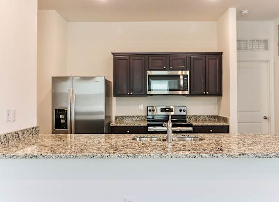 A kitchen with granite countertops and stainless steel appliances.