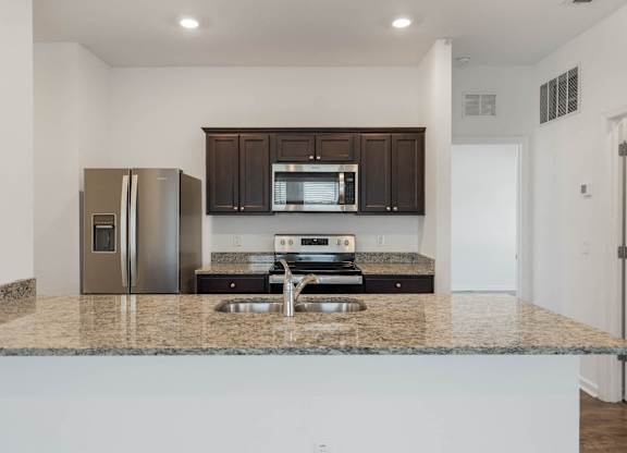 A kitchen with granite countertops and stainless steel appliances.