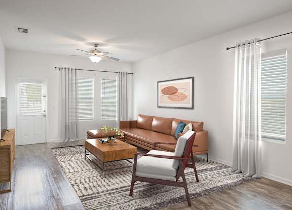 A living room with a brown couch, a coffee table, and a ceiling fan.