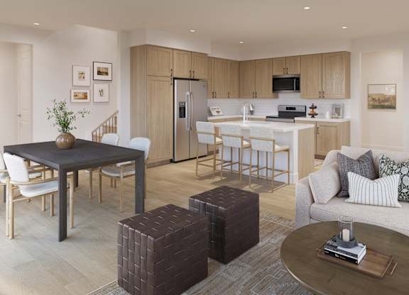 A modern living room with a dining area and kitchen in the background.