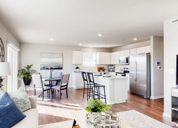 a living room with a kitchen and a table with chairs