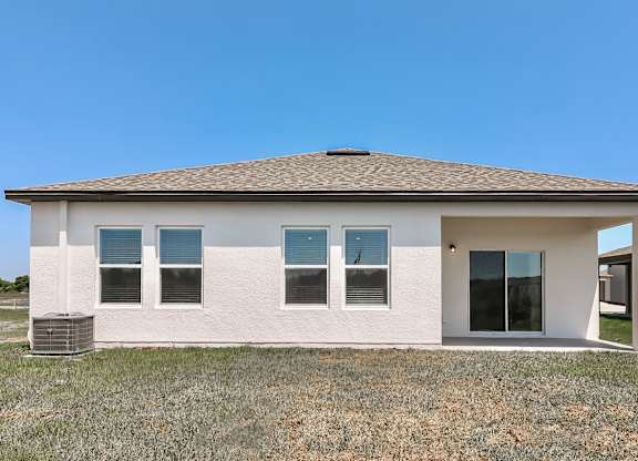 A white house with a brown roof and a glass door.