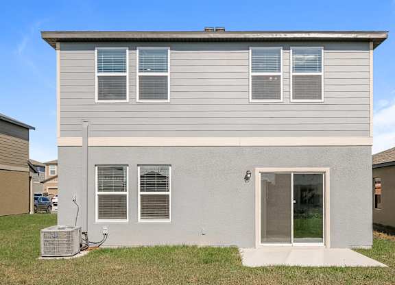 A grey house with a white door and windows.