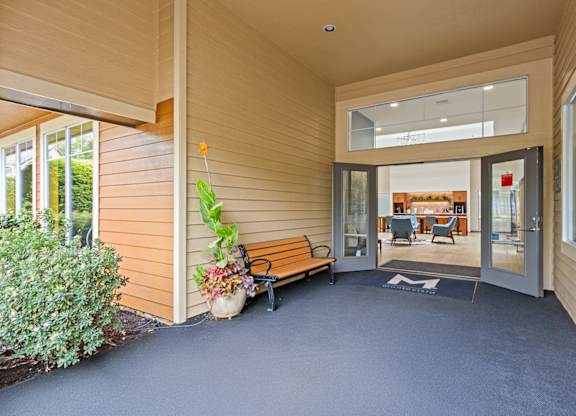 A wooden building with a bench and a plant in front at MonteVista Apartments, Beaverton
