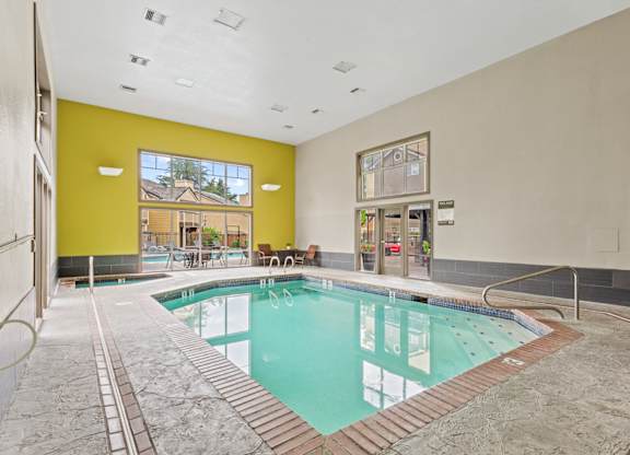 A large indoor swimming pool with a glass wall at MonteVista Apartments, Beaverton