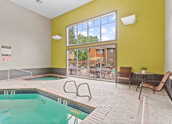 A swimming pool inside a building with a yellow wall at MonteVista Apartments, Oregon