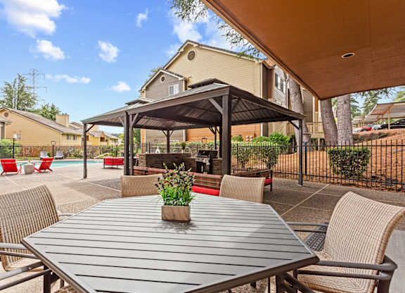 A patio with a table and chairs under a canopy at MonteVista Apartments, Oregon 97007