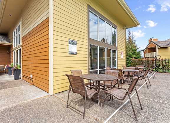 A yellow house with a patio table and chairs at MonteVista Apartments, Beaverton, Oregon