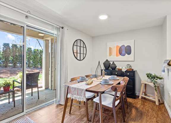 A dining room with a table set for two and a view of the backyard at MonteVista Apartments, Oregon 97007