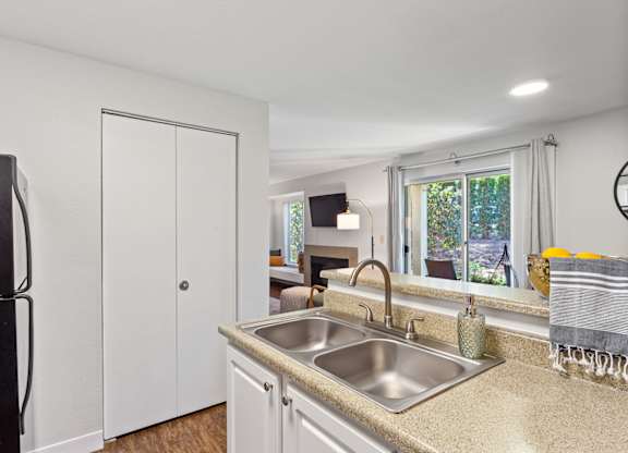 A kitchen with a sink, refrigerator, and a window at MonteVista Apartments, Beaverton, OR 97007