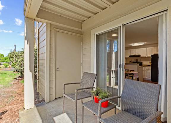 A patio with a chair and table is shown at MonteVista Apartments, Beaverton, 97007