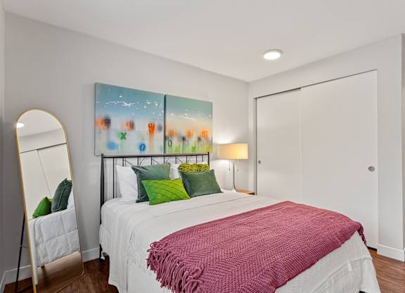 A bedroom with a large bed and a painting on the wall at MonteVista Apartments, Beaverton