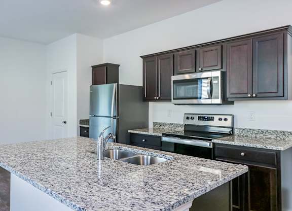 A kitchen with granite countertops and stainless steel appliances.