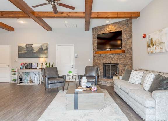 One, Two and Three- Bedroom Apartments for Rent in Sevierville, TN – Overlook at Allensville – clubhouse seating area with a fireplace and a couch.