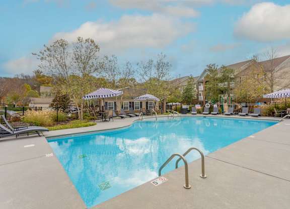 One, Two and Three- Bedroom Apartments for Rent in Sevierville, TN – Overlook at Allensville – A large swimming pool with seating areas and umbrellas