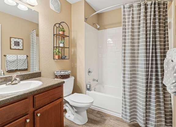 One, Two and Three- Bedroom Apartments for Rent in Sevierville, TN – Overlook at Allensville – A bathroom with a toilet, sink, and shower.