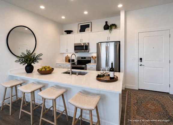 A kitchen with white cabinets and a white counter top.