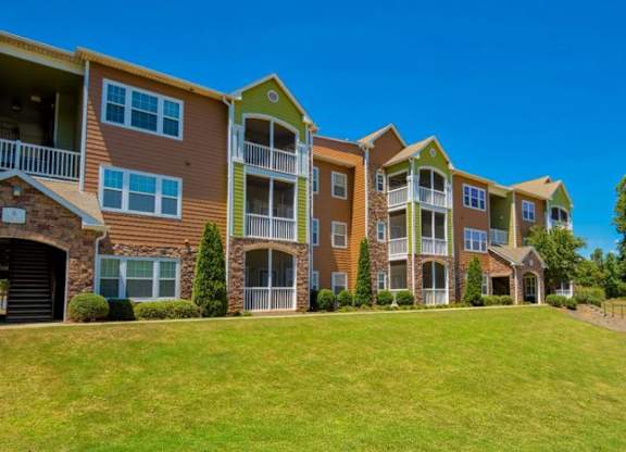 Pet-Friendly Apartments in Opelika, AL – The Crossings of Opelika - community building and grass area