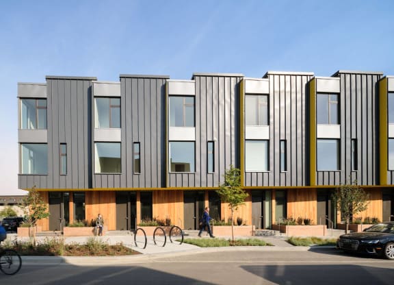 a rendering of a building with a person riding a bike in front of it